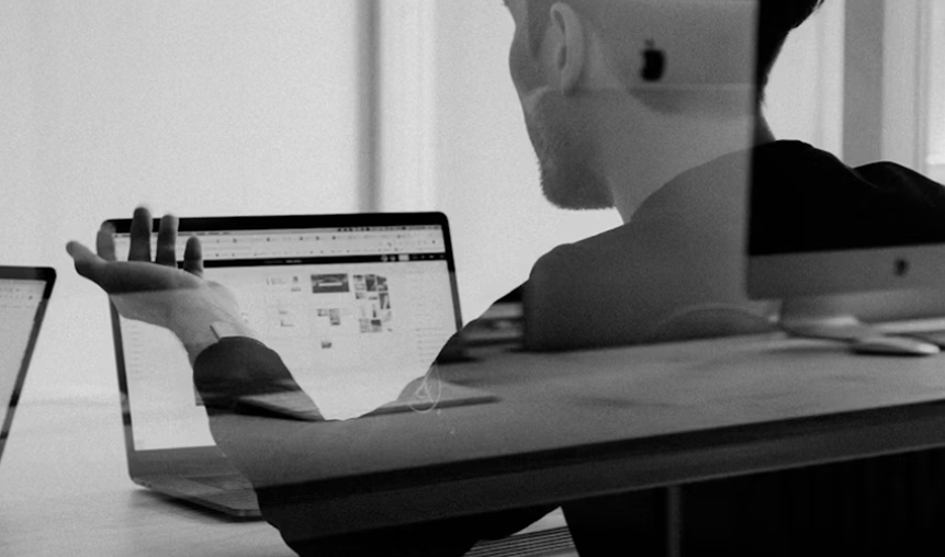 A young man consulting on his open laptop.